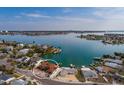 Aerial view of home with water views on the bay, a private dock, and mature tropical landscaping at 7013 Boca Ciega Dr, St Pete Beach, FL 33706