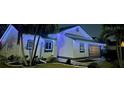 Night view of a single-story home illuminated with blue LED holiday lights, enhancing curb appeal at 8359 Wrens Way Pass, Largo, FL 33773