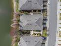 Aerial view of townhomes roofs with a community lake and nearby street at 8835 Moonlit Meadows Loop, Riverview, FL 33578