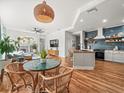 Open-concept living area with a modern kitchen, fireplace, and hardwood floors at 15720 Ibisridge Dr, Lithia, FL 33547