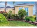 Detailed view of lush landscaping, including various plants, and a well-maintained lawn around the home at 1605 Emerald Dunes Dr, Sun City Center, FL 33573