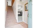 Inviting entryway with a staircase, light tile floors, and a view into a workshop or garage at 2003 Mcmullen Ave, Dunedin, FL 34698