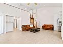 Spacious living room with a spiral staircase, comfortable leather sofas, and plenty of natural light at 2003 Mcmullen Ave, Dunedin, FL 34698