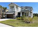 Charming two-story house featuring a two-car garage, second story balcony, and attractive landscaping at 33947 Astoria Cir, Wesley Chapel, FL 33545