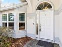 Close-up of the front door with an arched window above and manicured landscaping at 3414 Shady Brook Ln, Sarasota, FL 34243