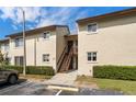 Exterior view of the two-story condo building featuring a staircase and well-maintained landscaping at 4215 E Bay Dr # 1601D, Clearwater, FL 33764