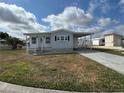 Cozy home with a carport and a tidy lawn on a sunny day at 4845 Baker Ave, Zephyrhills, FL 33541