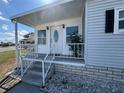 Close-up of a porch with white railings, steps, and an inviting front door at 4845 Baker Ave, Zephyrhills, FL 33541