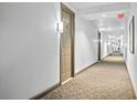 Long hallway with carpet flooring, leading to a door with room number, and an emergency exit sign at 700 S Harbour Island Blvd # 802, Tampa, FL 33602