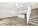 Open-concept living room with wood floors, staircase, and a modern kitchen featuring stainless steel appliances at 7529 62Nd N Way, Pinellas Park, FL 33781