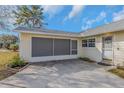 View of the home's front entrance and its screened-in side entry with a concrete patio at 10906 Covey Ct, Tampa, FL 33625