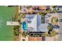 Home featuring a private backyard pool, a spacious patio, and a dock with direct water access at 11320 8Th E St, Treasure Island, FL 33706