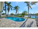 Private in-ground pool surrounded by a brick patio, lush landscaping and waterfront views at 11320 8Th E St, Treasure Island, FL 33706