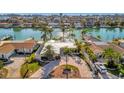 Beautiful home featuring a well-manicured lawn, circular driveway, and lush palm trees for tropical curb appeal at 11320 8Th E St, Treasure Island, FL 33706