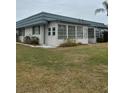 Attractive home exterior featuring an enclosed porch and meticulously kept landscaping at 1811 Bedford Ln # 162, Sun City Center, FL 33573