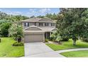 Charming two-story home with a well-manicured lawn and attached two-car garage at 19308 Sunset Bay Dr, Land O Lakes, FL 34638