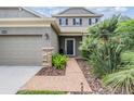 Inviting front entry with well maintained landscaping and a brick walkway at 19308 Sunset Bay Dr, Land O Lakes, FL 34638