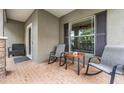 Cozy front porch with brick flooring and comfortable rocking chairs at 19308 Sunset Bay Dr, Land O Lakes, FL 34638