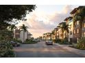 Charming street view featuring modern homes with covered parking, palm trees, and lush landscaping at 2 Aqua Reserve Blvd, New Port Richey, FL 34652