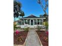 Charming home featuring a glass-enclosed porch and freshly landscaped yard with a walkway to the front door at 3221 17Th N St, St Petersburg, FL 33713