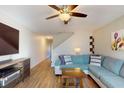 Cozy living room featuring wood floors, a comfortable couch, and natural lighting at 415 Kensington Lake Cir, Brandon, FL 33511