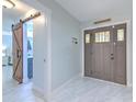 Spacious foyer featuring modern tile flooring, a decorative front door and barn door access to other rooms at 4810 Centerbrook Ct, Tampa, FL 33624