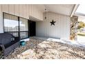 Charming front porch featuring a decorative star, stone accents, and a comfortable wicker chair at 8979 Hernando Way, Weeki Wachee, FL 34613