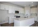Bright kitchen with white cabinetry, stainless steel microwave, oven, and island sink with ample counter space at 14441 Meadow Bird Ave, Riverview, FL 33579
