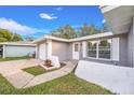 Close up of the front entrance with walkway and landscaped beds and painted accent wall at 1811 Forest Dr, Oldsmar, FL 34677