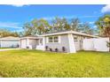 Angle view of a single-story home with lush green lawn, showcasing its freshly painted gray exterior at 1811 Forest Dr, Oldsmar, FL 34677