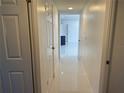 Hallway with white walls and trim, offering a glimpse into the open floor plan at 19109 Sunlake Blvd, Lutz, FL 33558