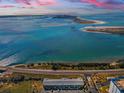 Breathtaking aerial view showcasing the waterfront location of the building, beautiful ocean, and highway at 2 Causeway Blvd # 208, Dunedin, FL 34698