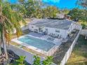 Aerial view of a backyard with a sparkling pool, hot tub, and patio furniture at 6961 Dalkeith N Ave, St Petersburg, FL 33709