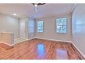 Bright living room with hardwood floors, two windows and neutral wall paint at 7570 Tamarind Ave, Tampa, FL 33625
