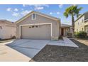 Charming single Gathering home with a two car garage, gray siding, and palm tree in the front yard at 8133 Canterbury Lake Blvd, Tampa, FL 33619