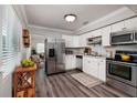 Bright kitchen with stainless steel appliances, white cabinets, and wood-look flooring at 921 57Th N Ave, St Petersburg, FL 33703