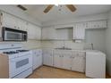 Efficient kitchen with white appliances, ample counter space, and linoleum flooring at 10116 Tulip N St # 10116, Pinellas Park, FL 33782