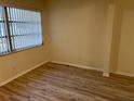 Cozy bedroom featuring wood-look floors, panelling and a window with blinds at 11200 102Nd Ave # 125, Seminole, FL 33778