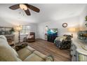 Bright living room with plush seating, modern ceiling fan, and wood-look flooring at 1710 Belleair Forest Dr # A, Belleair, FL 33756