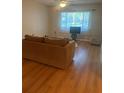 Bright living room featuring hardwood floors, and a large window at 2765 Countryside Blvd # 106, Clearwater, FL 33761