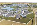 Aerial view of homes in a neighborhood with a lake, landscaping, and roadways at 2839 Gumbo Limbo Dr, Wimauma, FL 33598
