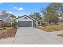 Charming one-story home with fresh landscaping, green grass, and healthy bushes in the front yard at 3038 Longbrooke Way, Clearwater, FL 33760