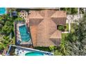 Aerial view of a home featuring a screened pool, an in-ground pool, and an outdoor fire pit at 3217 Taragrove Dr, Tampa, FL 33618