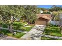 Charming single Gathering home with well maintained lawn, mature tree, and two car garage at 3217 Taragrove Dr, Tampa, FL 33618