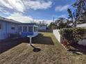 The backyard has a birdbath, an air conditioner, a partial view of a sunroom, and a white fence at 3398 53Rd N St, St Petersburg, FL 33710