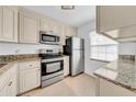 Bright kitchen featuring stainless steel appliances, granite countertops, and neutral cabinetry at 4647 Lake Villa Dr, Clearwater, FL 33762