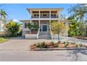 Two-story home featuring a metal roof, front balcony and a paved driveway with attractive landscaping at 5010 W Dickens Ave, Tampa, FL 33629