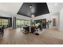 Bright living room showcasing the black accent ceiling, wood-look floors, and natural light at 7934 Lakes Edge Ln, Port Charlotte, FL 33981