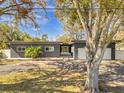 Contemporary gray home featuring a two-car garage, well-maintained landscaping, and a unique driveway at 8040 Owl Rd, Seminole, FL 33777