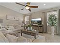 Cozy living room features a ceiling fan, tile floors, neutral colors, and lots of natural light at 10136 Grand Oak Cir, Madeira Beach, FL 33708
